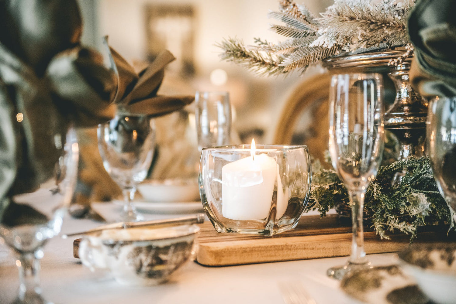 cozy table setting with champagne glasses, pine branches and candle